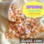 A large, overflowing white bowl of vibrant Spring Candy Coated Popcorn, with individual pieces adorned with white chocolate, marshmallows, and colorful M&M