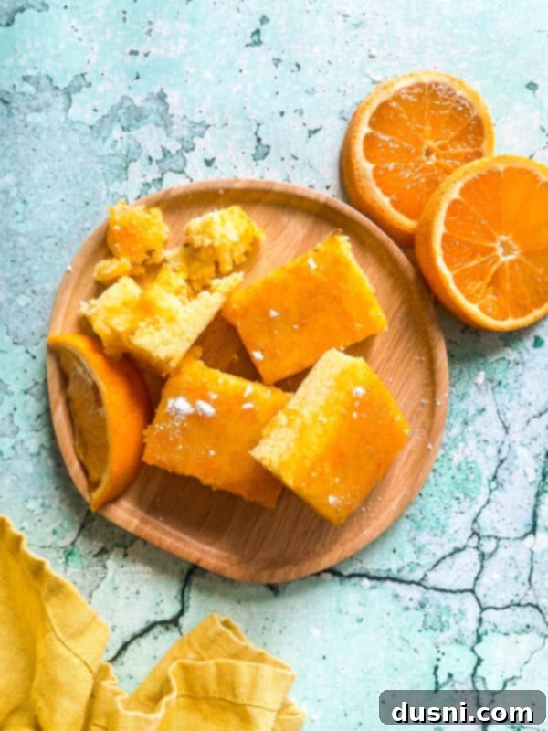 Sunshine Orange Bars 13 Fresh Orange Bars on a wooden plate against a blue background, arranged neatly.
