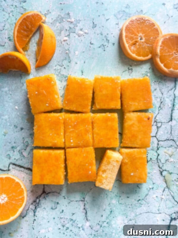 Sunshine Orange Bars 15 Fresh Orange Bars cooling on a blue background, ready for serving.