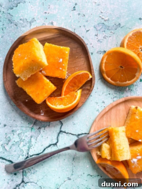 Sunshine Orange Bars 3 Fresh Orange Bars on a wooden plate against a blue background, ready to be served.