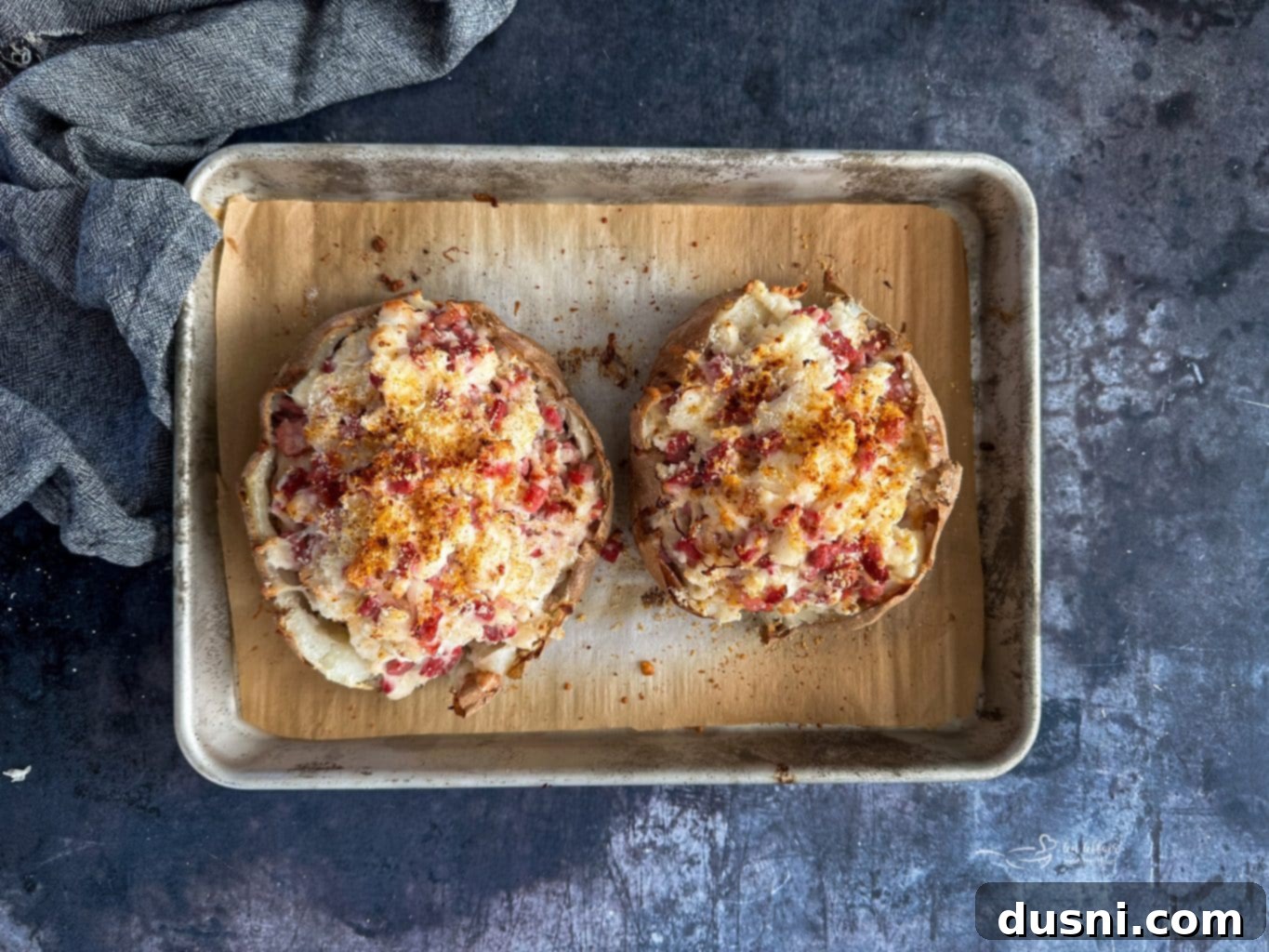 Reuben stuffed baked potato topped with Parmesan and paprika