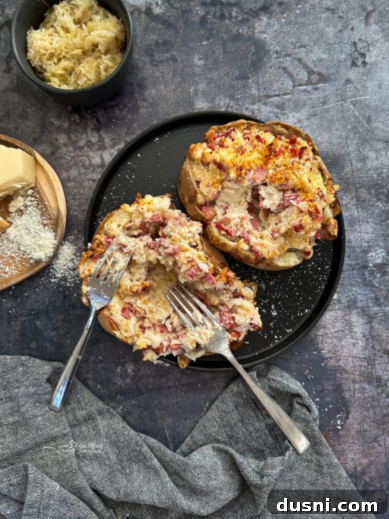Two Reuben stuffed baked potatoes on a white plate