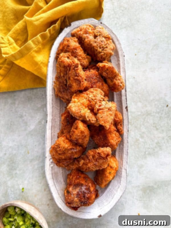 Honey-Glazed Crispy Fried Chicken 4 Stack of crispy chicken pieces on a plate.