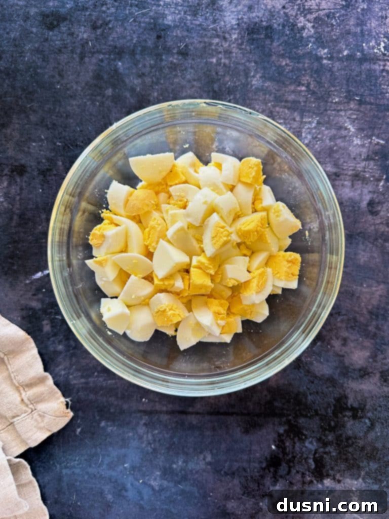 Cooked elbow macaroni being rinsed under cold water in a colander.