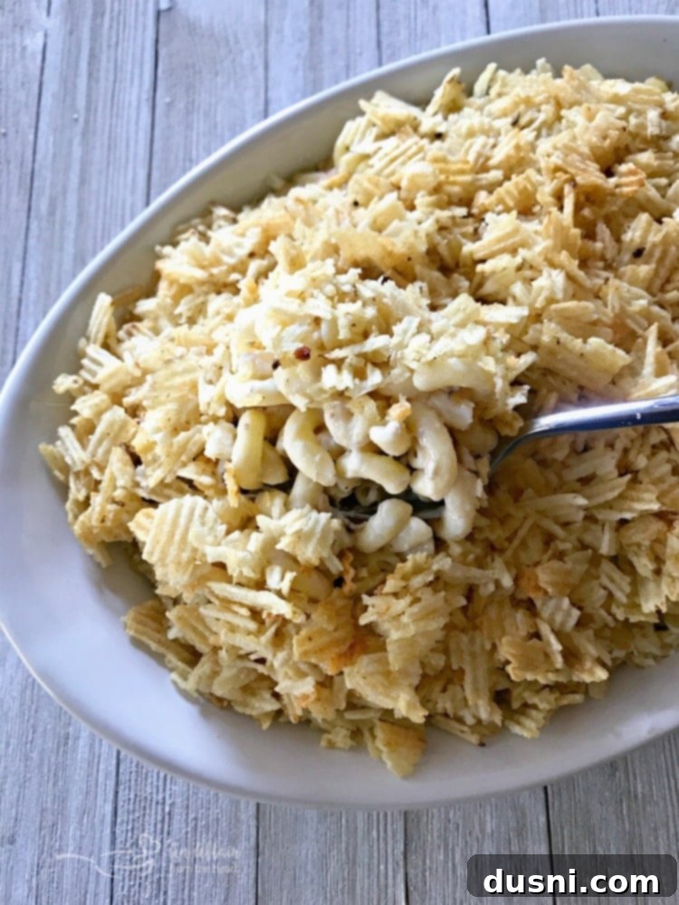Scooping a generous portion of Mom's Tuna Tetrazzini Casserole from a baking dish