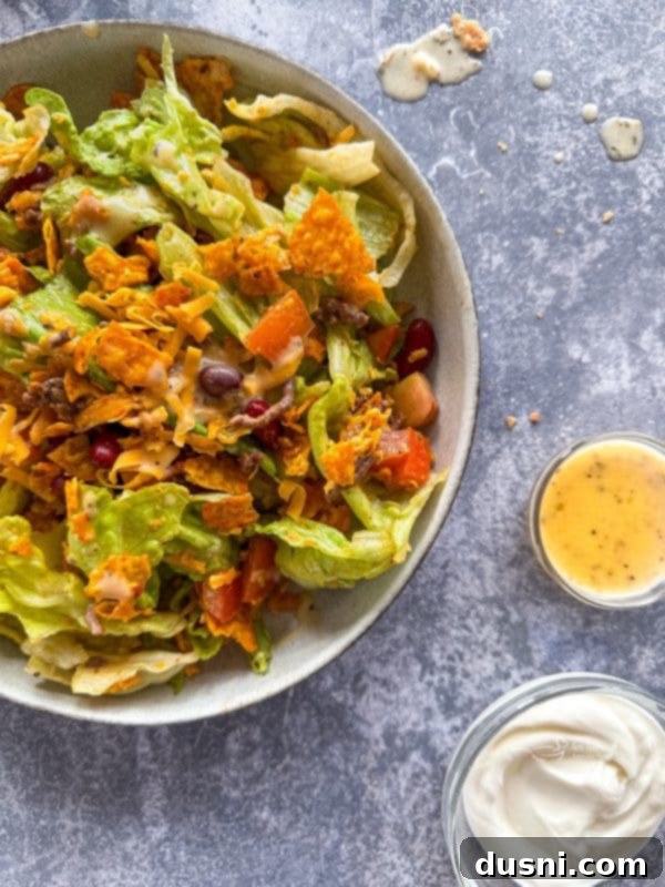 Ultimate Doritos Taco Salad 2 A vibrant Doritos Taco Salad in a large serving bowl, ready to be enjoyed with fresh ingredients.