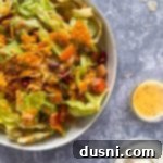 Ultimate Doritos Taco Salad 16 Extreme close up of Sue's Doritos Taco Salad in a white bowl, showing fresh ingredients.