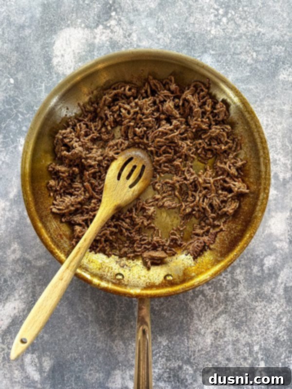 Ultimate Doritos Taco Salad 6 Ground beef browning in a skillet for the taco salad, showing the cooking process.