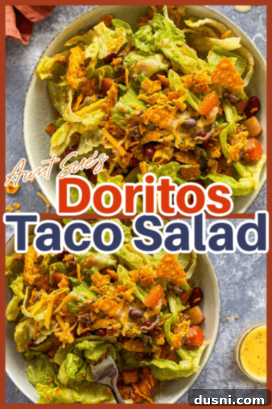 Ultimate Doritos Taco Salad 10 A beautiful, fully dressed Doritos Taco Salad in a white bowl, garnished and ready to serve, with a blurred background.