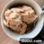 Creamy Peanut Butter Banana Delight 11 overhead of peanut butter banana ice cream and a spoon in a white bowl.