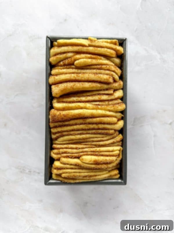 Warm Cinnamon Pull-Apart Perfection 14 Stacking cut dough strips into a loaf pan