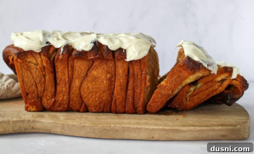 Warm Cinnamon Pull-Apart Perfection 18 A whole loaf of cinnamon pull apart bread with frosting and a missing piece