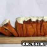 Warm Cinnamon Pull-Apart Perfection 21 Side view of cinnamon pull apart bread with cream cheese frosting on a wooden board