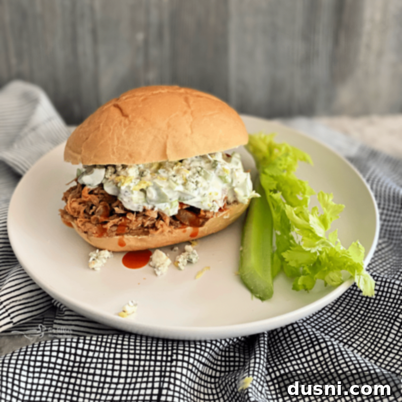 slow cooker buffalo pulled pork sandwich on white plate