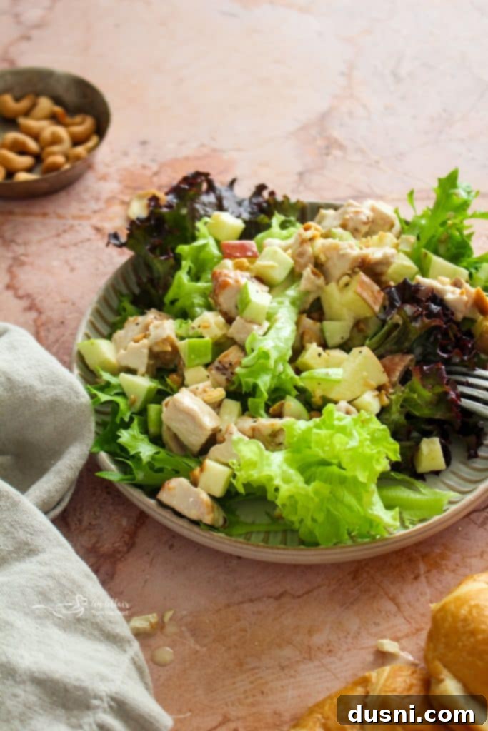 Close-up of Apple Chicken Salad in a bowl, showing chicken pieces, diced apples, and cashews.