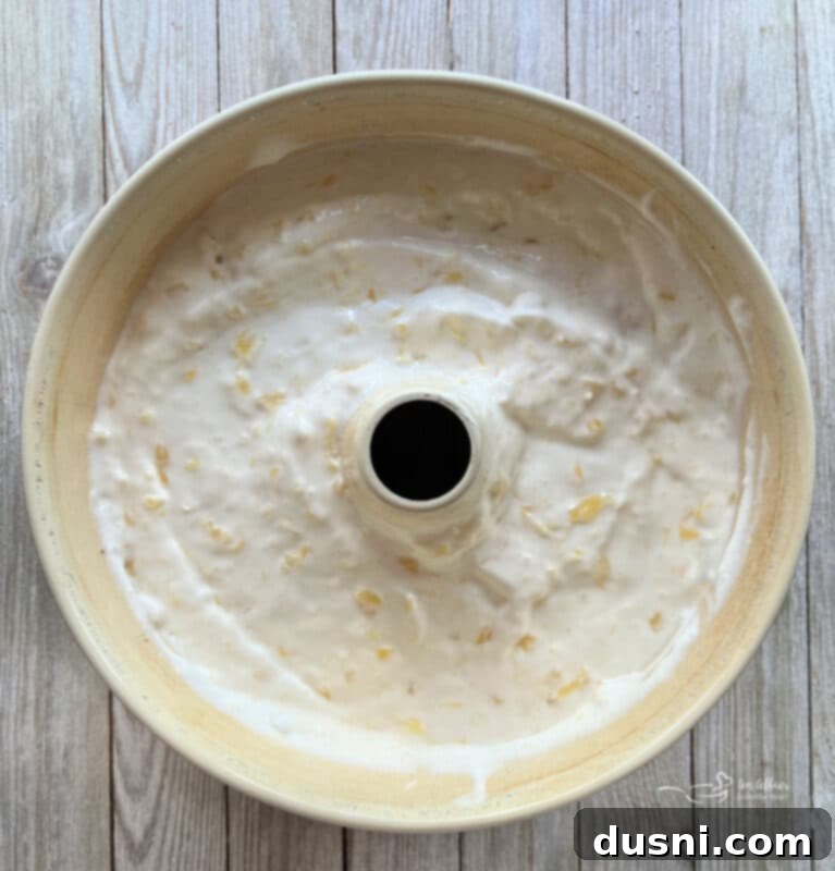 Angel food cake batter being mixed on medium speed, showing a well-combined, fluffy consistency