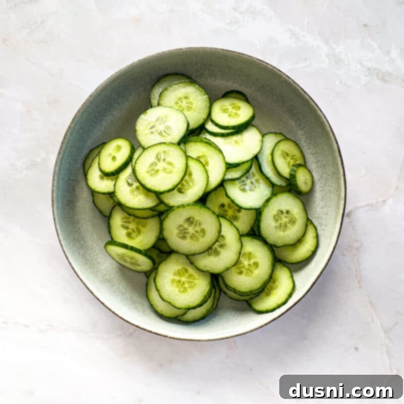 Step 3: Thinly slicing fresh cucumbers for the baguettes