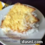 Close up of a slice of Pineapple Coconut Tunnel Cake on a white plate