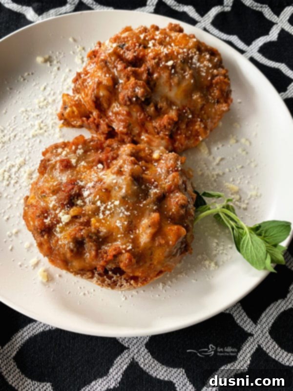 Pizza Burger Melts 2 Open-Faced Pizza Burgers on a white plate, garnished with fresh basil