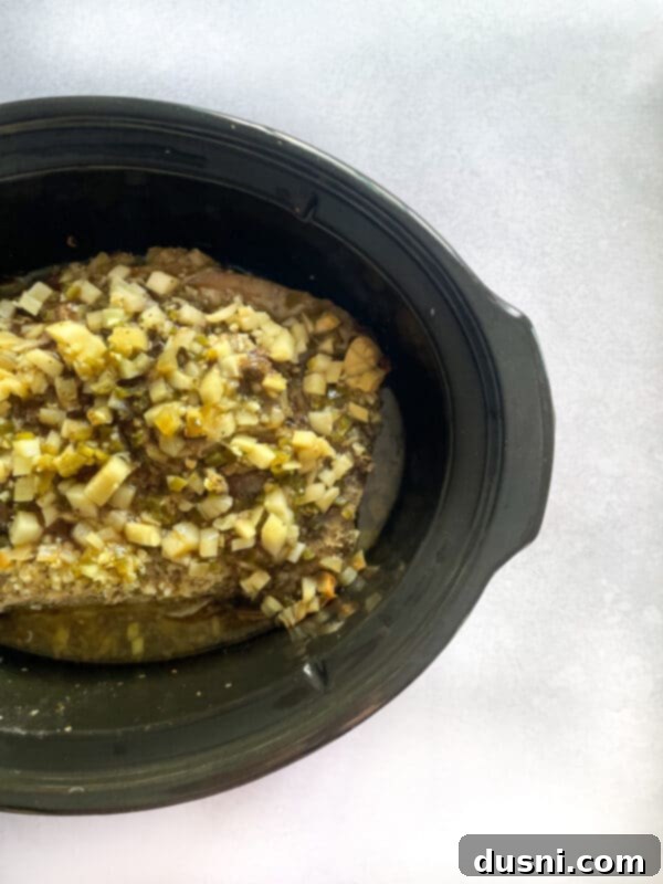 Crispy Tender Slow Cooker Carnitas 12 Squeezing orange juice over carnitas in slow cooker