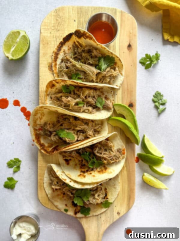 Crispy Tender Slow Cooker Carnitas 17 Slow Cooker Carnitas tacos served with lime and cilantro