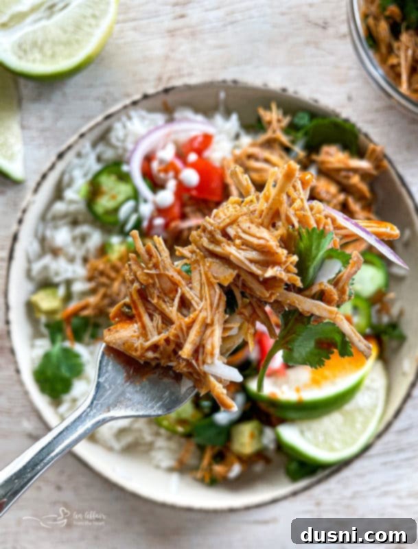Crispy Tender Slow Cooker Carnitas 18 One bowl of cilantro lime pork with limes, tomatoes, onions, rice, and jajapeños