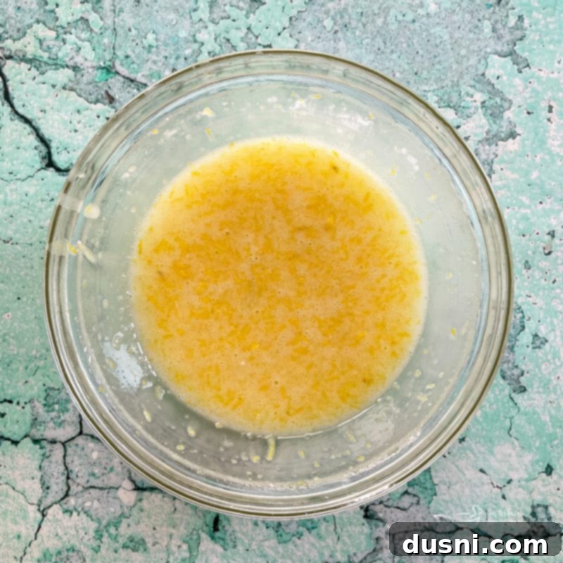 a bowl of lemon glaze being whisked until smooth and creamy, showing its ideal texture