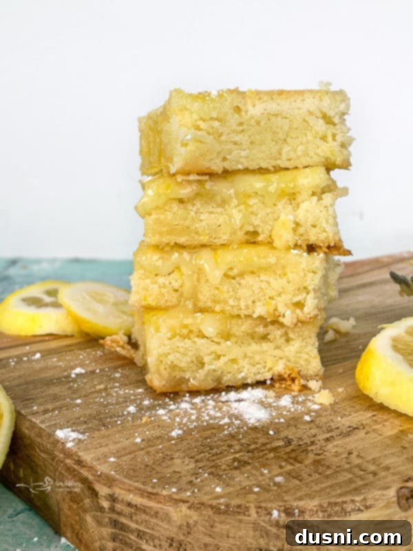front stack of three glazed lemon brownies, showcasing the thick lemon glaze and tender interior