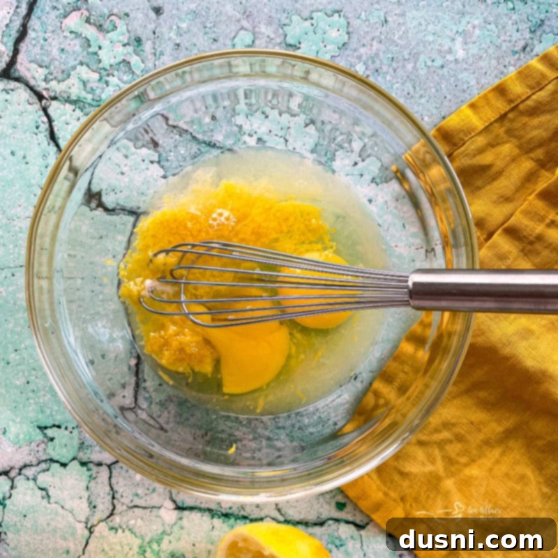 eggs, lemon zest, and lemon juice in a glass bowl, ready to be whisked for the brownie batter