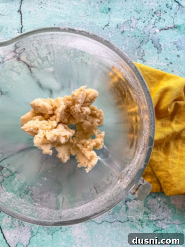 creamed butter and sugar in a mixing bowl with dry ingredients, forming the initial brownie batter