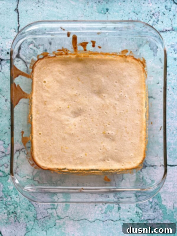 freshly baked lemon brownies in a baking dish, with golden brown edges and a soft center