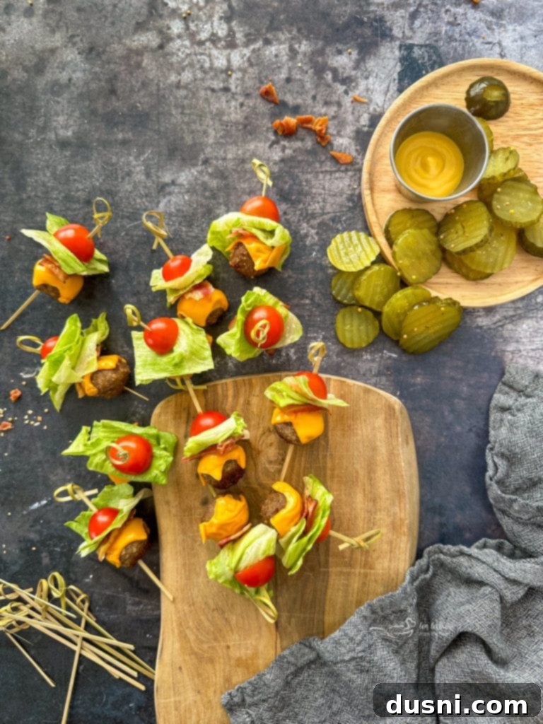 Bacon Cheeseburger Meatballs, fresh out of the oven, topped with melted cheese and fresh garnishes