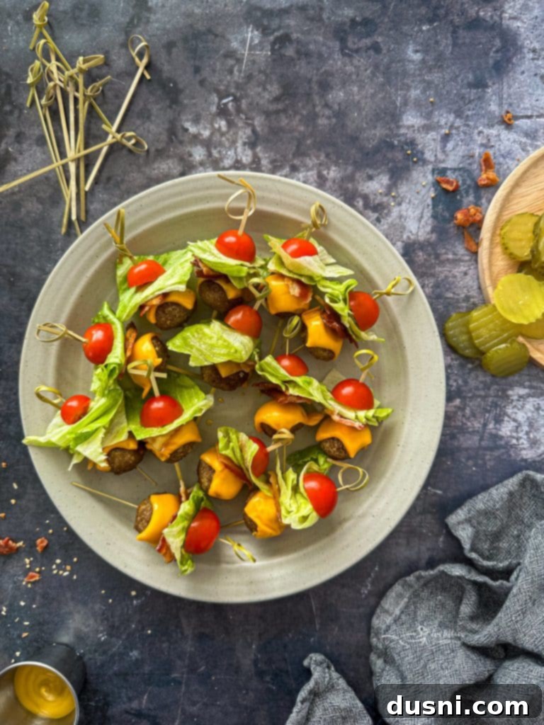 A spread of Bacon Cheeseburger Meatballs with various dipping sauces