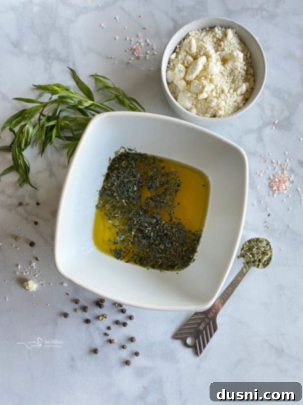 Hellenic Cucumber Medley 6 A small white bowl containing a whisked mixture of olive oil, tarragon vinegar, and dried oregano, ready to be drizzled.