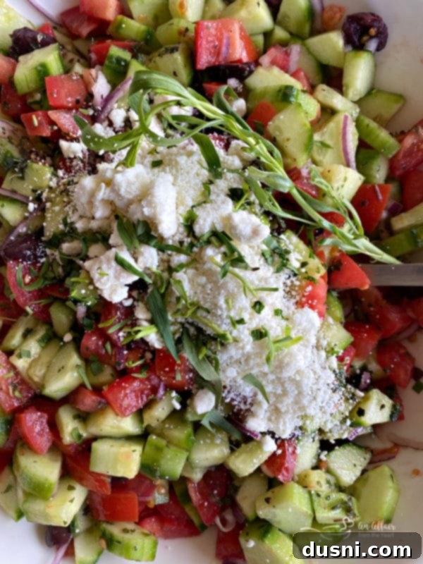 Hellenic Cucumber Medley 9 Top view of Greek cucumber salad, freshly mixed, with a sprinkle of salt, pepper, and optional fresh tarragon for seasoning.