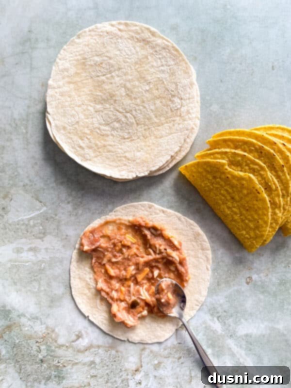 Spreading refried beans onto a flour tortilla