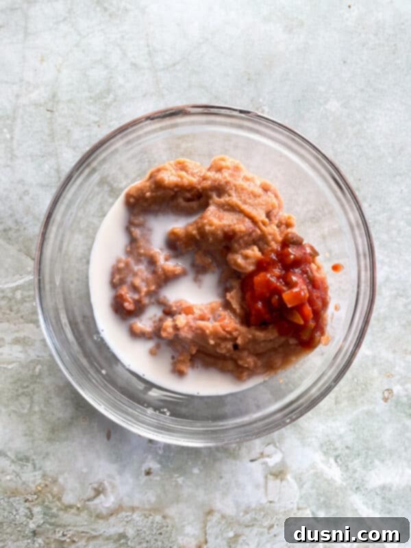 Refried beans, milk, and salsa in a bowl