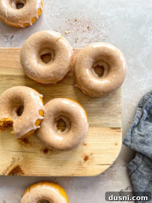Freshly baked pumpkin donuts cooling on a wire rack before glazing