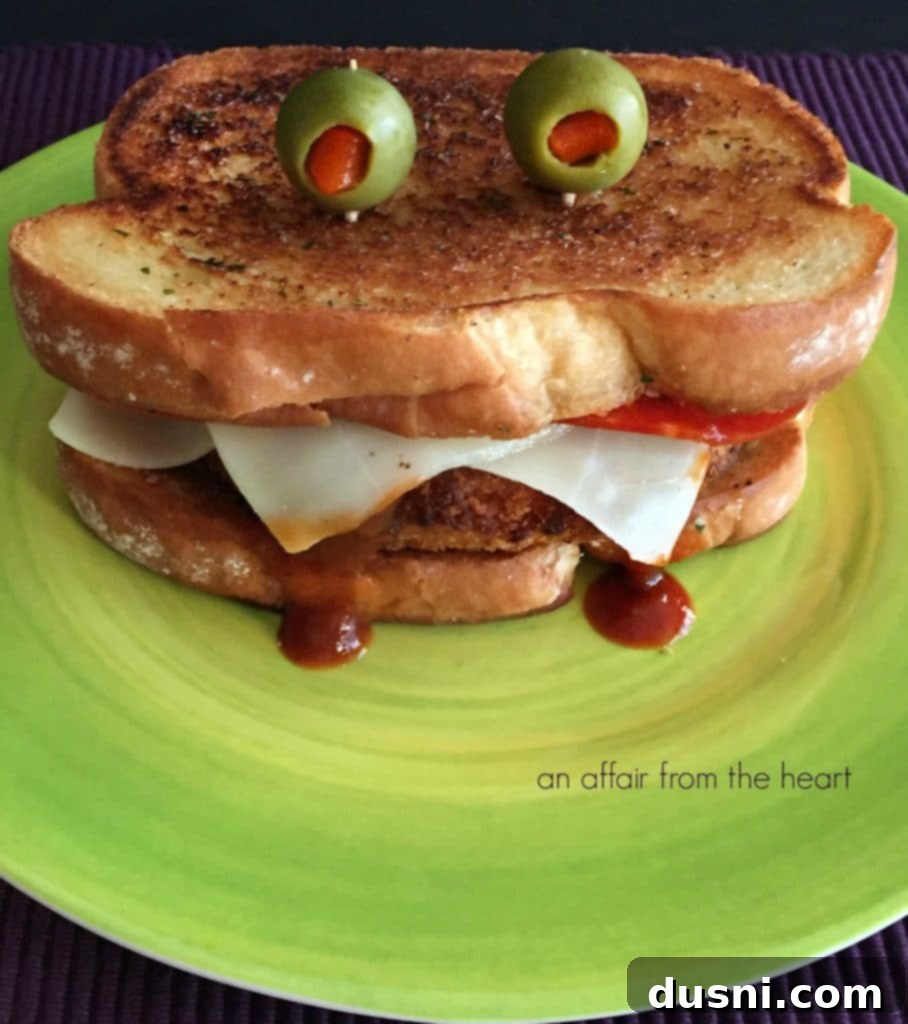 Close-up of a Pizza Monster Sandwich with melted mozzarella fangs and green olive eyes