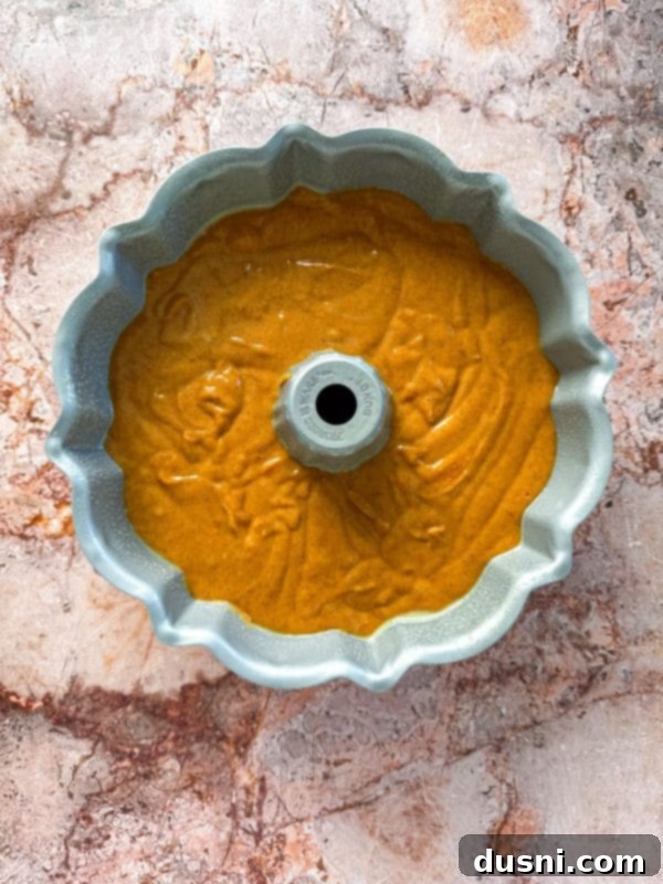 Pumpkin Bundt Cake batter being poured into a bundt pan