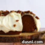 Pumpkin Bundt Cake with Cream Cheese Frosting (Cinderella Cake) on a wooden serving plate