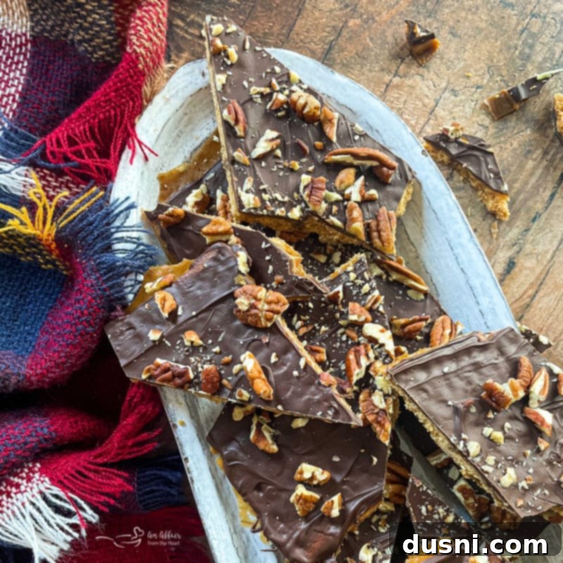 Homemade Graham Cracker Toffee 3 broken up pieces of toffee bark with pecans on white oval dish