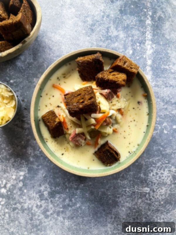 Indulgent Cream of Reuben Soup 11 Close-up of creamy Reuben soup being scooped from a Dutch oven