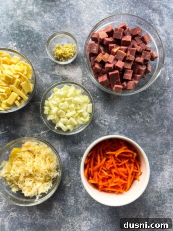 Indulgent Cream of Reuben Soup 4 Fresh ingredients laid out for creamy Reuben soup: chicken stock, corned beef, sauerkraut, onion, garlic, oregano, white pepper, bay leaf, cornstarch, carrots, Swiss cheese, heavy cream