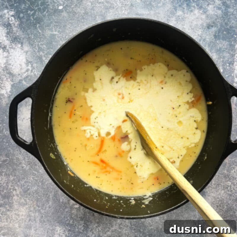 Indulgent Cream of Reuben Soup 9 Stirring heavy cream into creamy Reuben soup in a Dutch oven