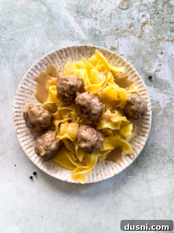 Close-up of golden brown Swedish meatballs in a creamy sauce, ready to be served