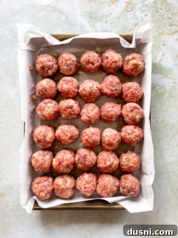 Hand rolling a portion of the meat mixture into a perfectly round Swedish meatball