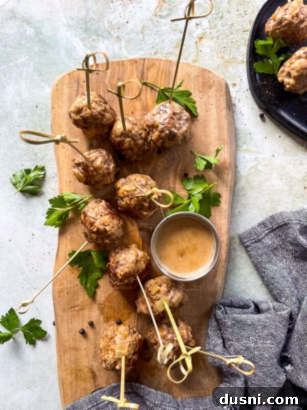 A close-up shot of creamy Swedish meatballs in a pan, simmering in their rich gravy