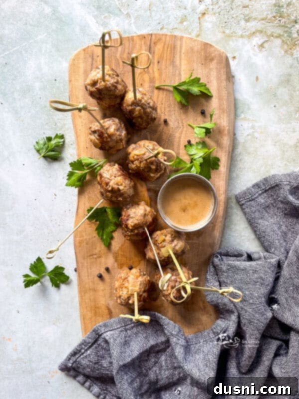 A close-up view of golden brown Swedish meatballs cooked in a pan before the sauce is added