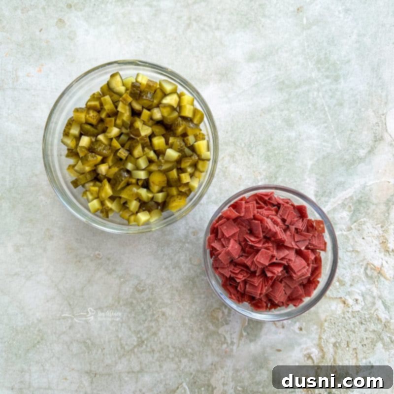 Zesty Dill Pickle Dip 7 Hands chopping dried beef and dill pickles on a cutting board